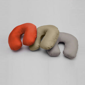 Three neck pillows in red, beige, and gray on a light gray background