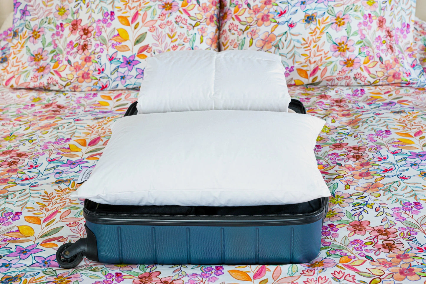 Guildcraft's travel duvet and travel pillow ready to be packed in a suitcase.