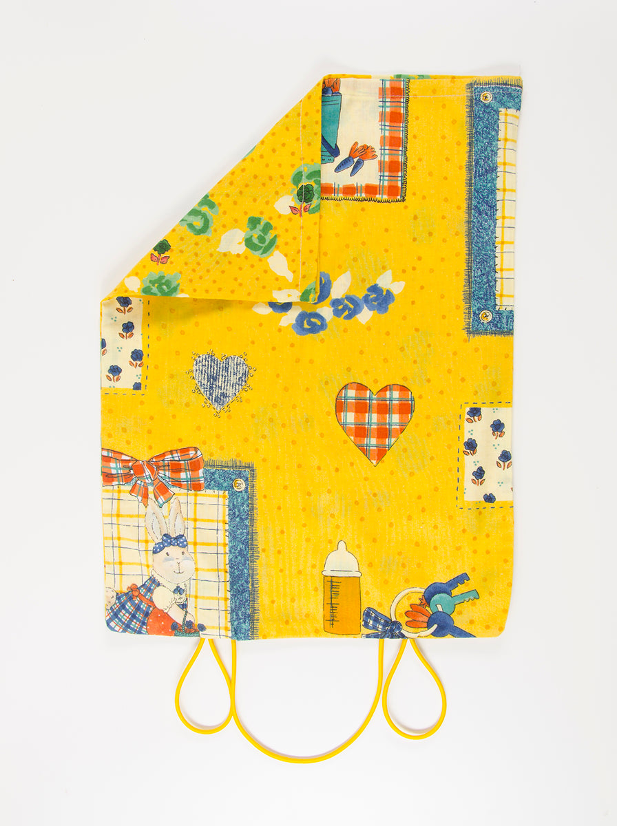 A back side of a yellow pattern Down Port-A-Bull Travel Pillow 14" x 18" sham (#013) with hoops that allow compact size for travelling.