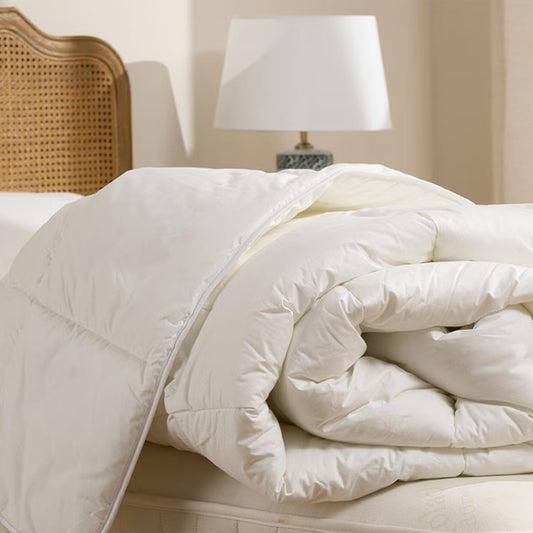 White duvet rolled up on a bed