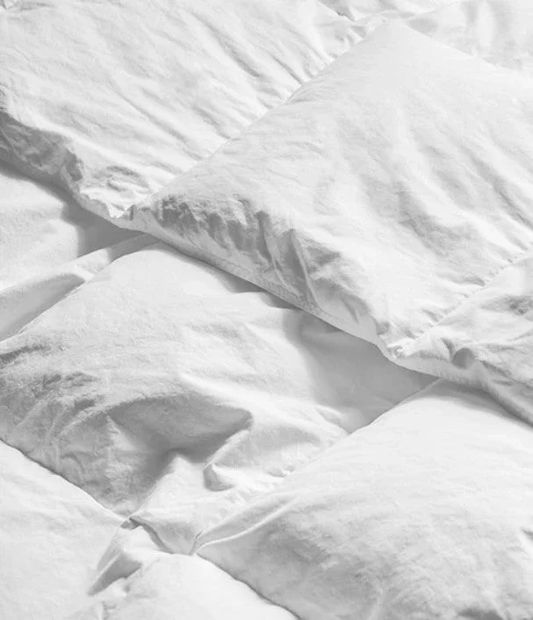 Soft down duvet lying on a bed.