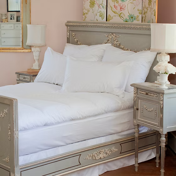 Decorative bed with Allergy Mattress Topper Protector, ornate headboard and nightstands in a bedroom setting.