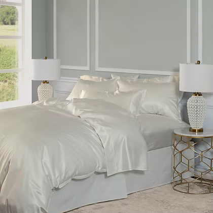 White satin Avorio | Silk Duvet Cover Set on a bed with matching pillows, placed in a bedroom setting.