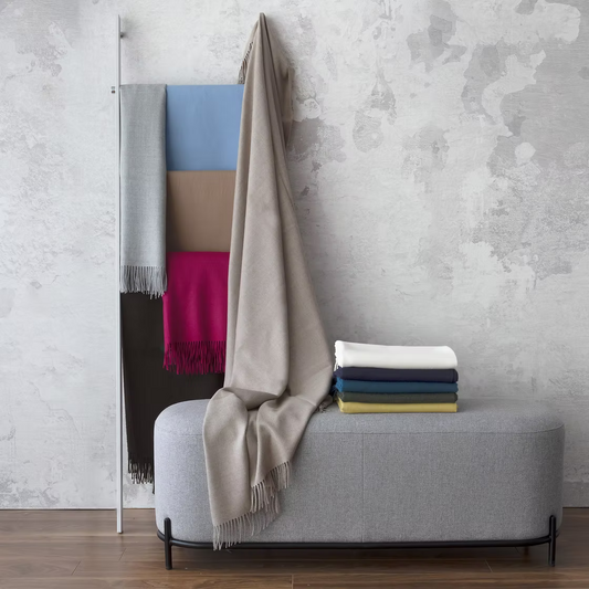 Alfie Baby Alpaca Throw in different colors on a hanger 