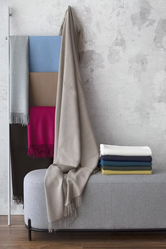 Alfie Baby Alpaca Throw in different colors on a hanger 