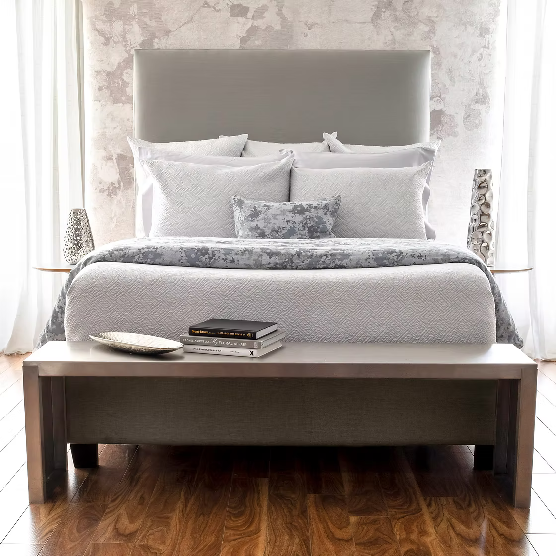 Neatly made bed with gray Scala Matelassé bedding and pillows in a bedroom setting.