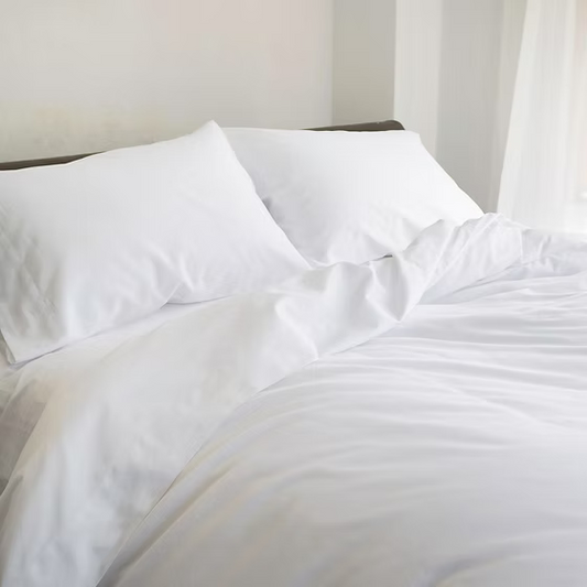 White Giza 92 Classic | Sateen bedding set on a bed with white pillows and duvet.