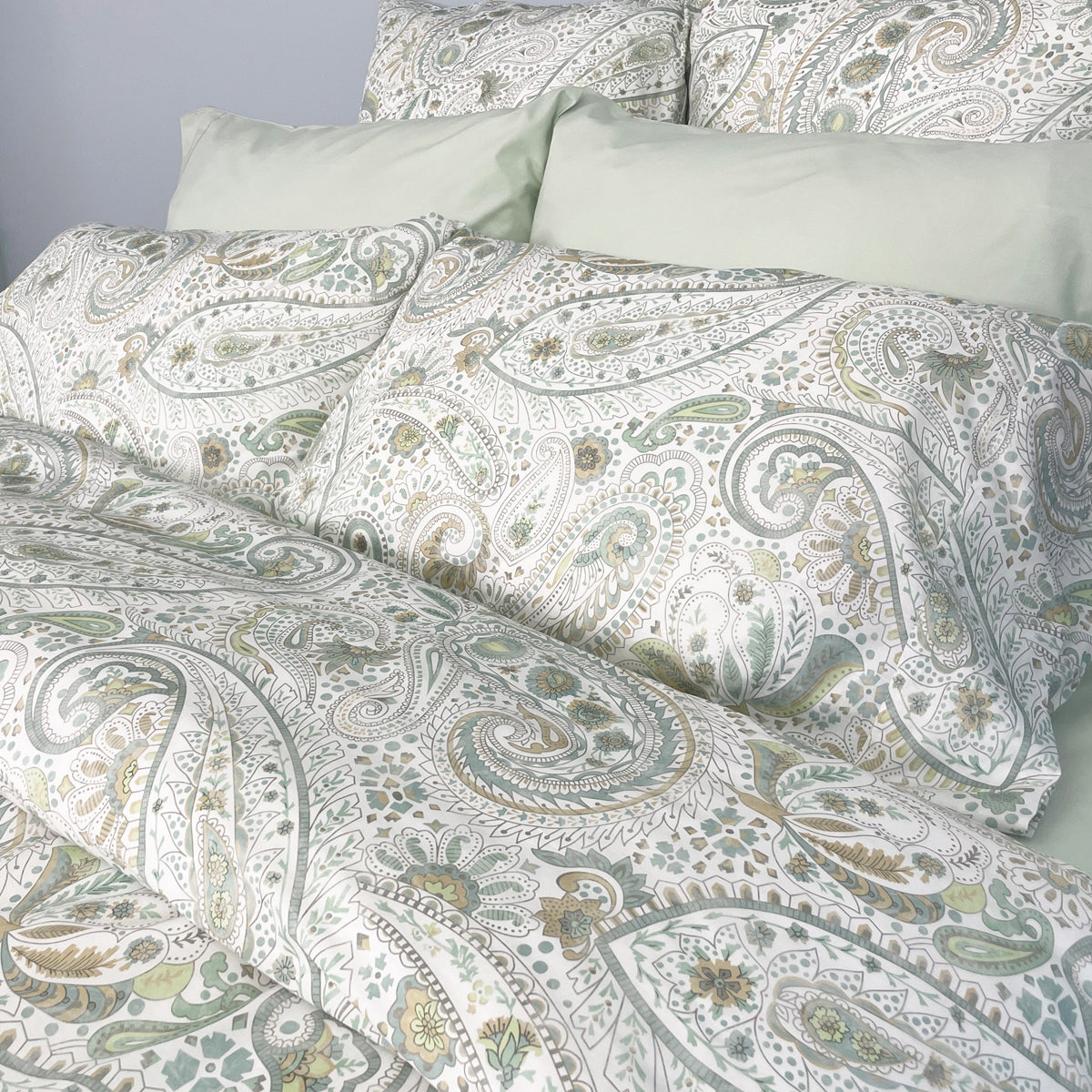 A set of four Annabelle duvet covers with a paisley pattern, placed on a bed.