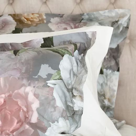 A closeup on a bed and a pillow with floral Bijoux Duvet Cover
