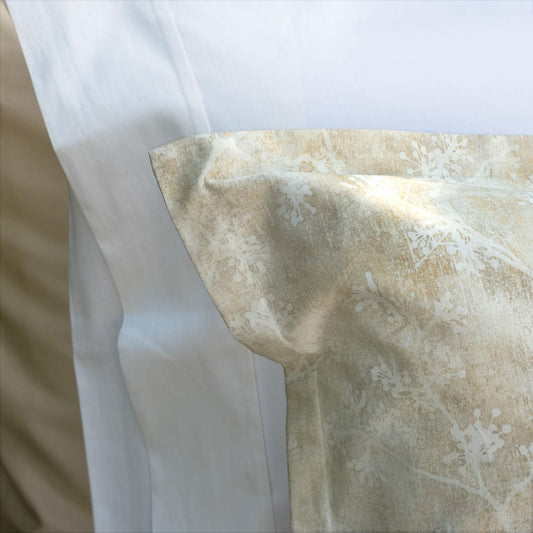 Close-up of a Daria beige sateen pillowsham with a floral pattern and a 1-inch flange, part of a bedding set.
