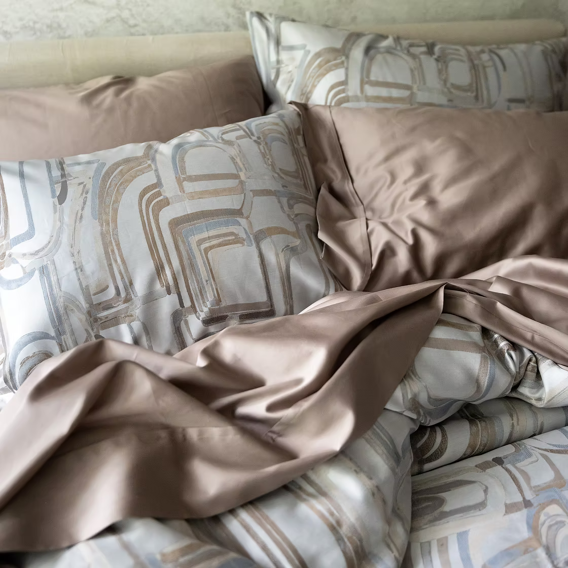 A bed with Fjord Shams and other bedding from Fjord collection