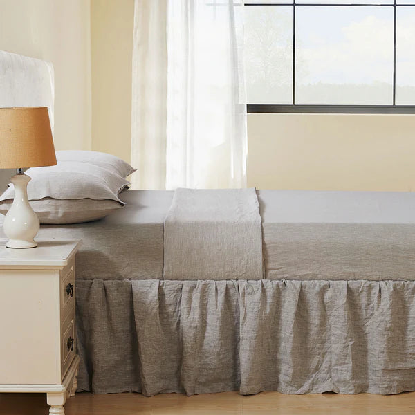 Neatly made bed with beige French Linen Sheet Set in a bright bedroom.