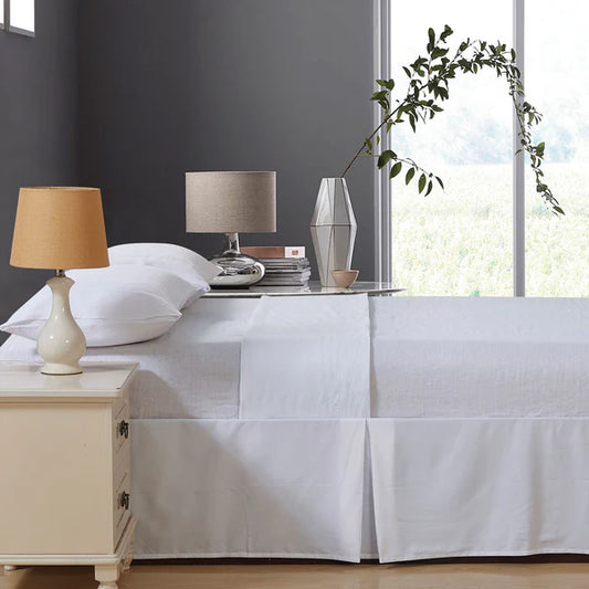 Bedroom with white bedding, nightstands, and lamps near a window and French Linen Sheet Set.
