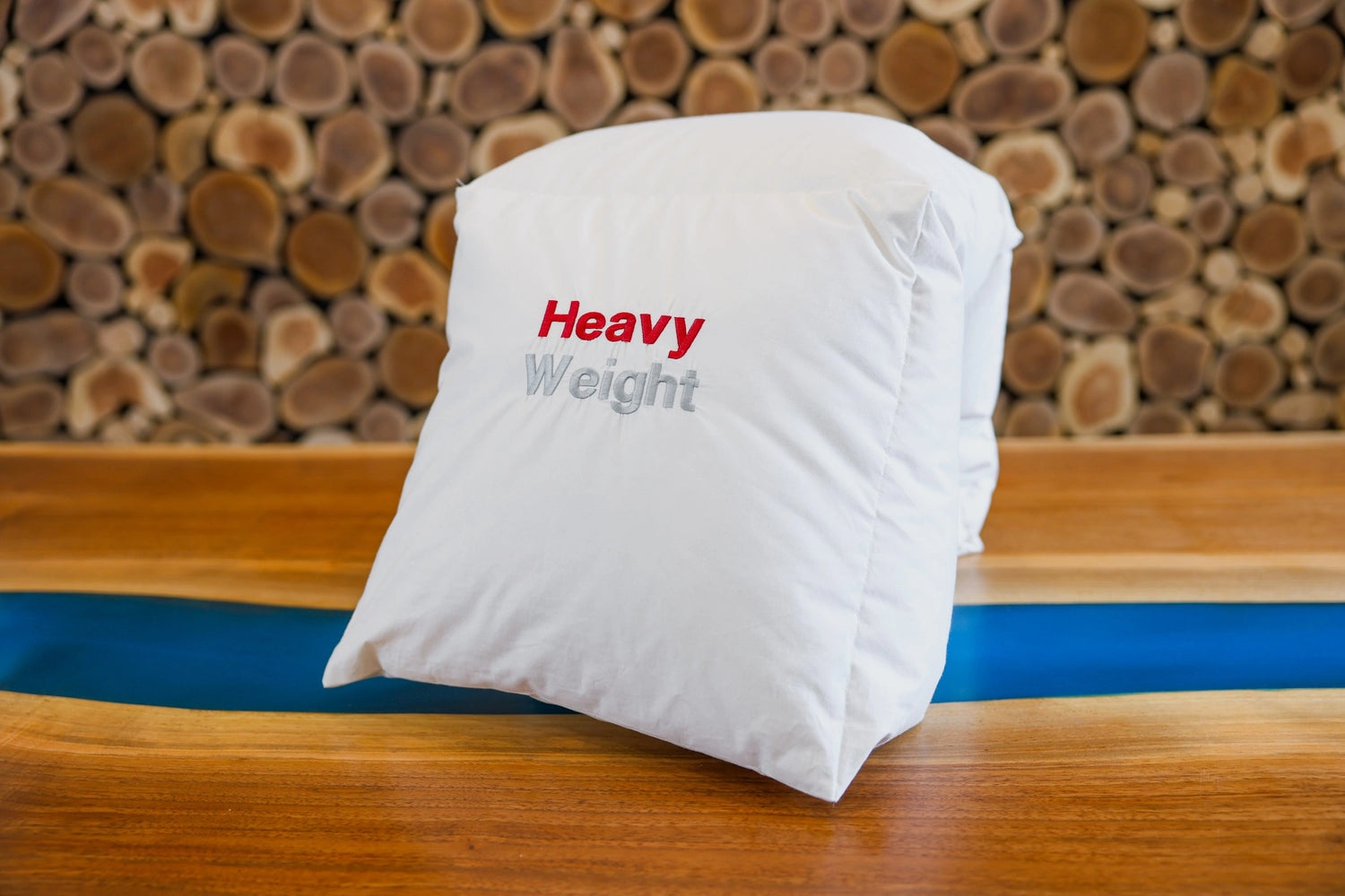 Neatly folded heavy weight down duvet placed in front of a wooden wall.