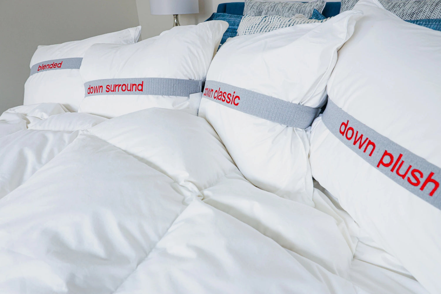 Pure down pillows by Guildcraft spread on a bed with a focus on classic pillow.