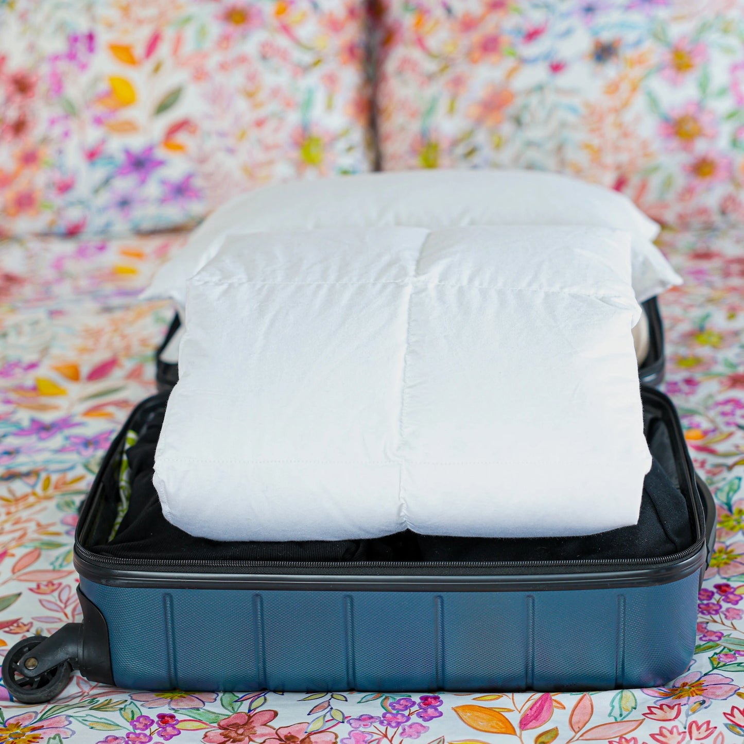 Travel duvet neatly packed in a open suitcase.