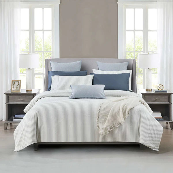 Neatly made bed with blue and gray Vale Shadow Duvet Cover Set in a bright bedroom.