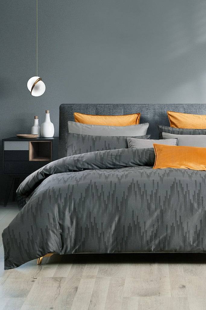 A Darian Grey Duvet Cover Set displayed on a bed, including a cover and pillowcases, with a subtle animal pattern.